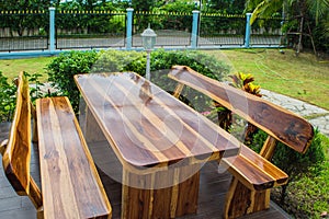 A wooden dining table set in lush garden setting