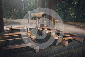 Wooden dipper of holy zen water at the entrance of a shrine in J