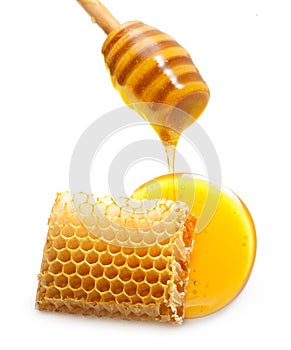 Wooden dipper, honey drop and honeycomb