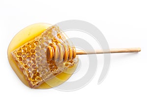 Wooden dipper, honey drop and honeycomb