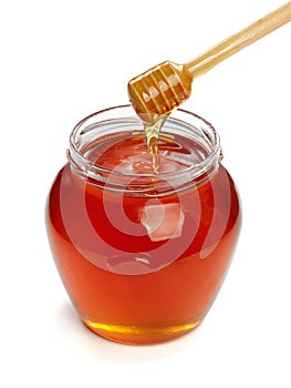 Wooden dipper with jar of honey.