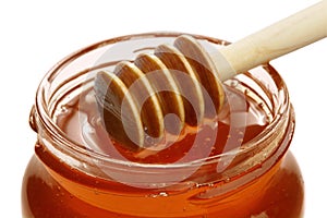 Wooden dipper with jar of honey.