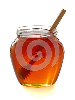 Wooden dipper with jar of honey.