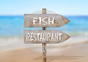 Wooden direction sign with fish restaurant