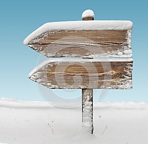 Wooden direction sign with snow and sky bg. two_arrows-one_direction
