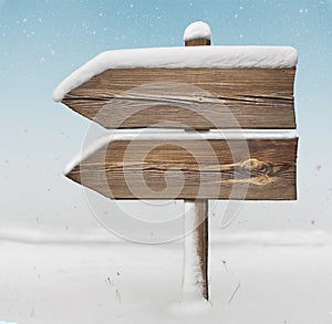 Wooden direction sign with less snow and snowfall bg. two_arrows-one_direction