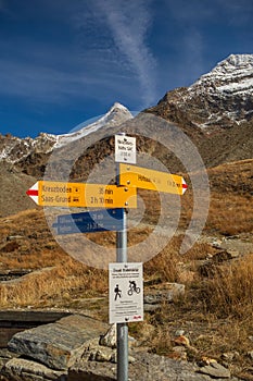 Wooden directional signpost with arrows pointing in multiple directions in the Swiss Alps