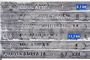 Wooden directions sign in winter in Finnish Lapland, Saariselka, Finland photo