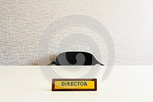 Wooden director office plate on white glossy table with empty chair in room