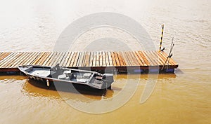 Wooden dock with a boat anchored on it.