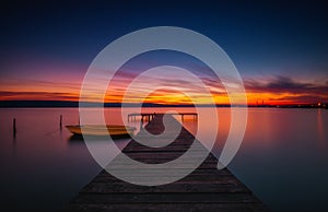 Wooden Dock and fishing boat at the lake, sunset shot