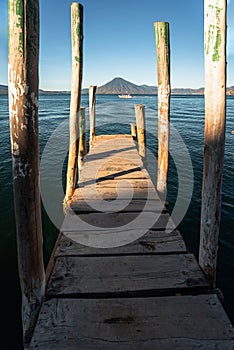 Wooden dock on Lake Atitlan on the beach in Panajachel, Guatemala. With Toliman and San Pedro volcanoes in the background