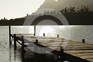 Wooden Dock In Lake At Sunset