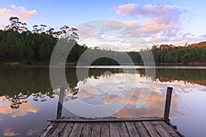 Wooden dock on serene lake with sunset