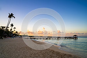 Wooden dock and shore at sunrise at Bayahibe beach, Dominican Republic photo