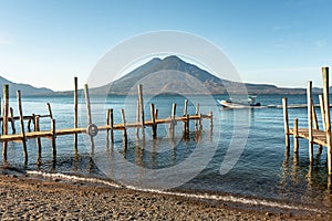 Wooden docks on Lake Atitlan on the beach in Panajachel, Guatemala. With Toliman and San Pedro volcanoes in the background