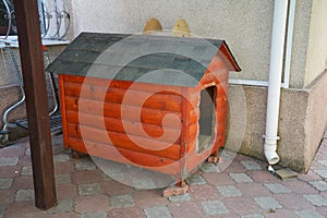 Wooden doghouse  inthe yard. Wooden dog house near house wall for home protection