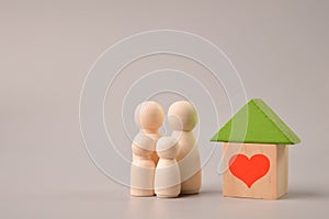 Wooden doll figures, toy house and heart symbol
