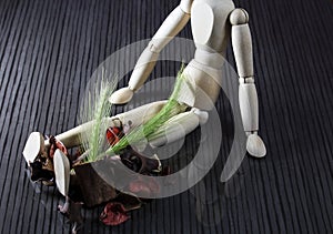 Wooden doll with fresh cereal stalks on the legs, many dried spring fruits lie next to it