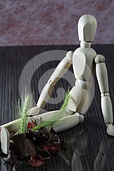 Wooden doll with fresh cereal stalks on the legs, many dried spring fruits lie next to it