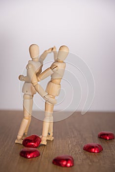 A wooden doll man in valentine day. Showing love on the wooden floor with warmth.