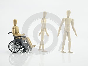 Wooden doll in wheelchair, steps for rehabilitation