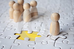 Wooden dolls on jigsaw with missing jigsaw puzzle. Hiring and employment concept