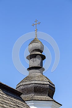 Wooden dome with orthodox cross of ancient ukrainian church against blue sky in Kyiv, Ukraine