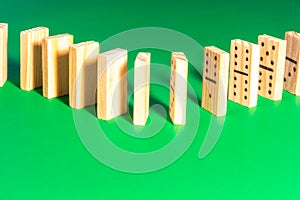 Wooden Dominoes Lined Up on Solid Green
