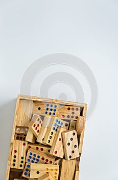 Wooden dominos in wooden box on white background with selective focus