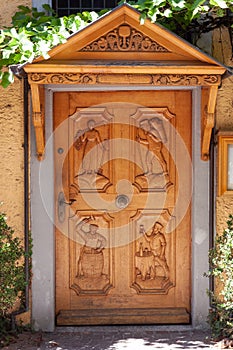 Wooden door with carvings of people depicting winemakers