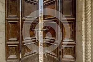 A wooden door closed by a chain with padlock at the entrance to one of the many buildings destroyed by the 2016 earthquake, Norcia