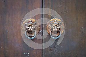 Wooden door detail with lion door knockers close up, Asia. Chinese style architecture of temple .