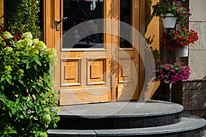 Wooden door with glass insert and iron handle.