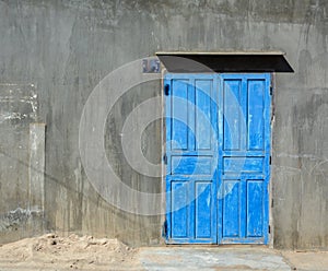 The wooden door with gray wall in Tra Vinh, Vietnam