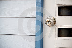 Wooden door with grill, stainless door knob or handle on wooden door in beautiful lighting.