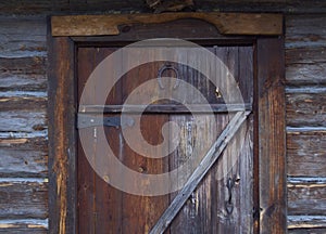 Wooden door of an old barn with metal hinges