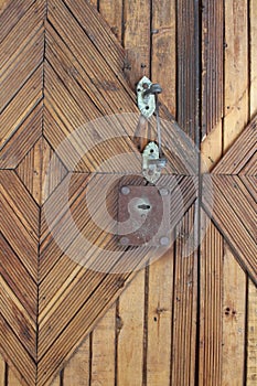 Wooden door with old metal lock and rusty handle in the house