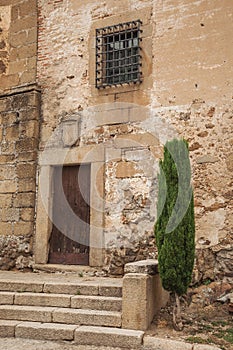 Wooden door in old stone building and staircase in Plasencia