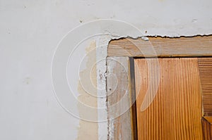 Wooden door, plastered wall. Door frame without platband. Rough