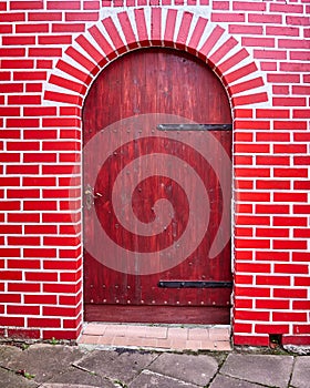 Wooden door and red bricks wall