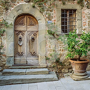 Wooden door in a small village of medieval origin. Volpaia, Tuscany, Italy