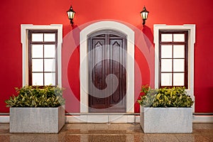 Wooden door with windows. Portugal Windows. Bright red colored facade of house