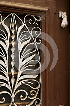 Wooden door with wrought iron details and doorknocker hand shaped