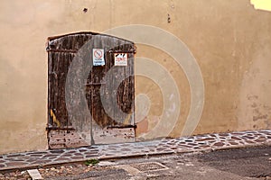 Wooden door in a yellow facade at noon
