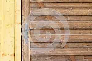 Wooden doors in brown and yellow color with a metal handle