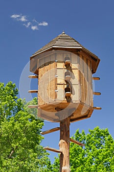 The wooden dovecote on the background of the blue sky