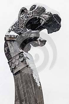 wooden dragon head on Drakkar in the grey sky