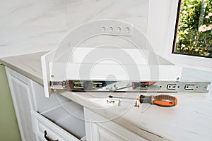 Wooden drawer with ball bearing slide mount, screwdriver and screws on the table.