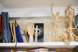 Wooden drawing mannequin dummy, doll to learn how to draw the human body in position of movement, on shelf in art store.